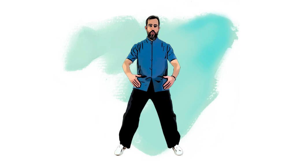 Un hombre con una camisa azul y pantalones negros está de pie con las manos en las caderas.