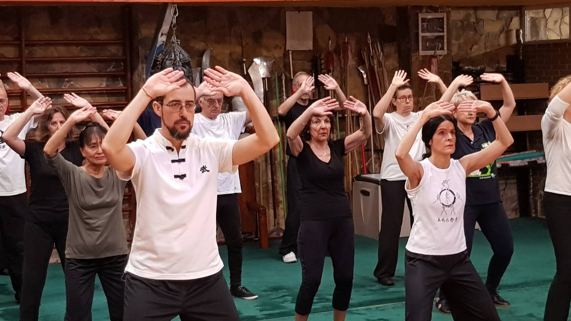 Un grupo de personas está practicando artes marciales en un gimnasio.