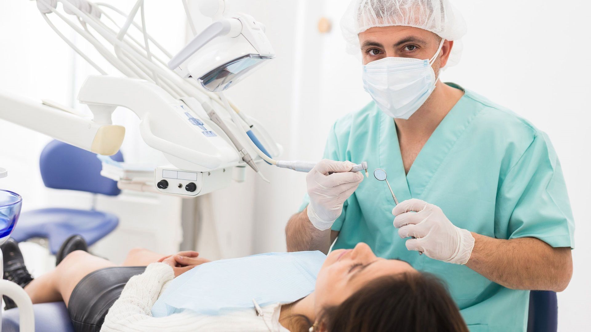 Un dentista está examinando los dientes de una mujer en un consultorio dental.