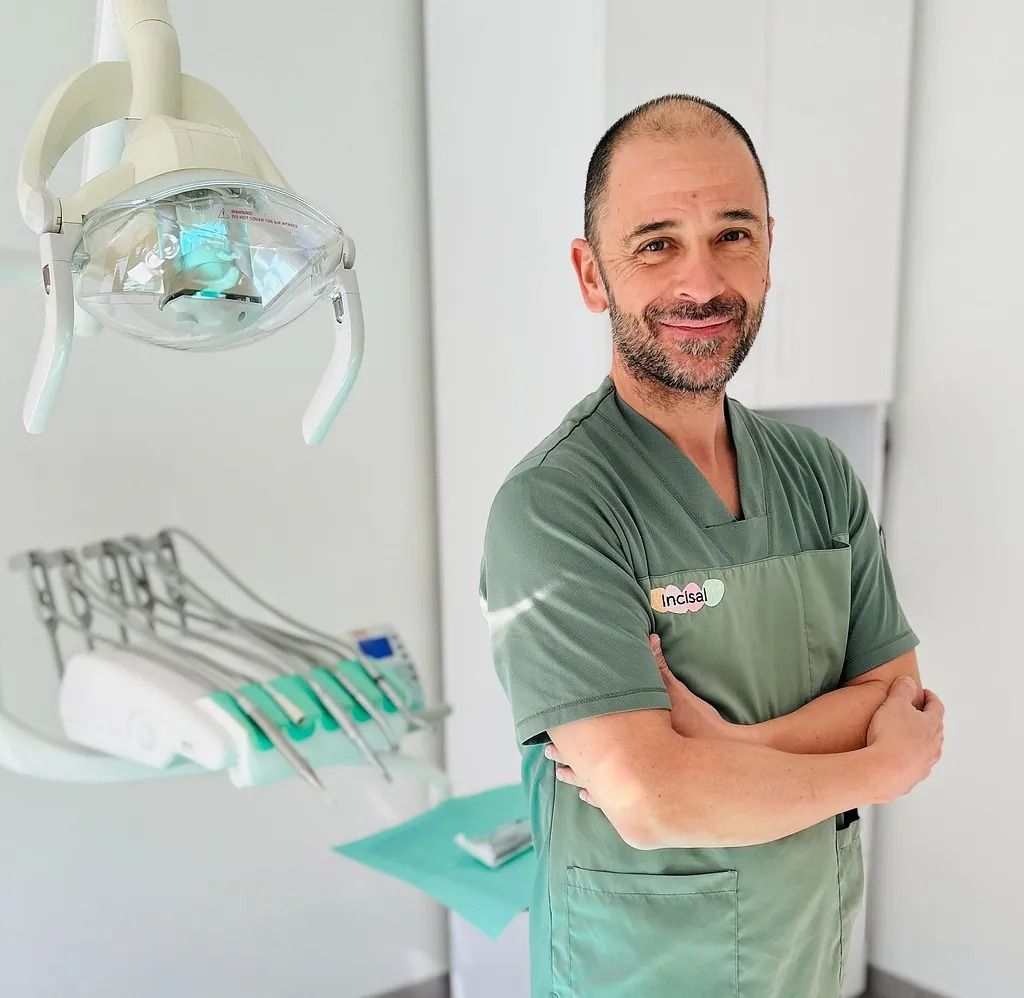 Un hombre en un consultorio dental con los brazos cruzados.