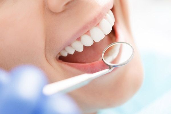 Una mujer está siendo examinada por un dentista.