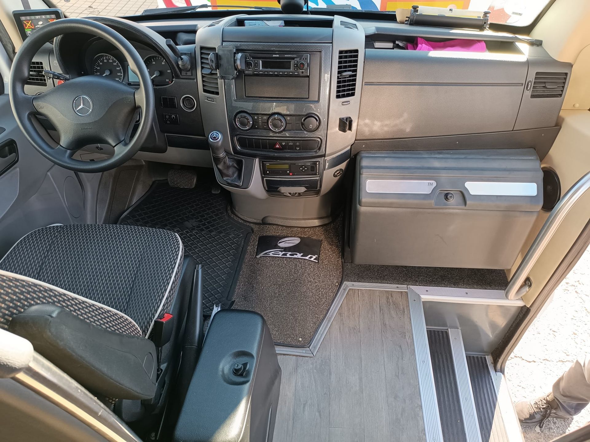 El interior de un autobús con volante y asientos.