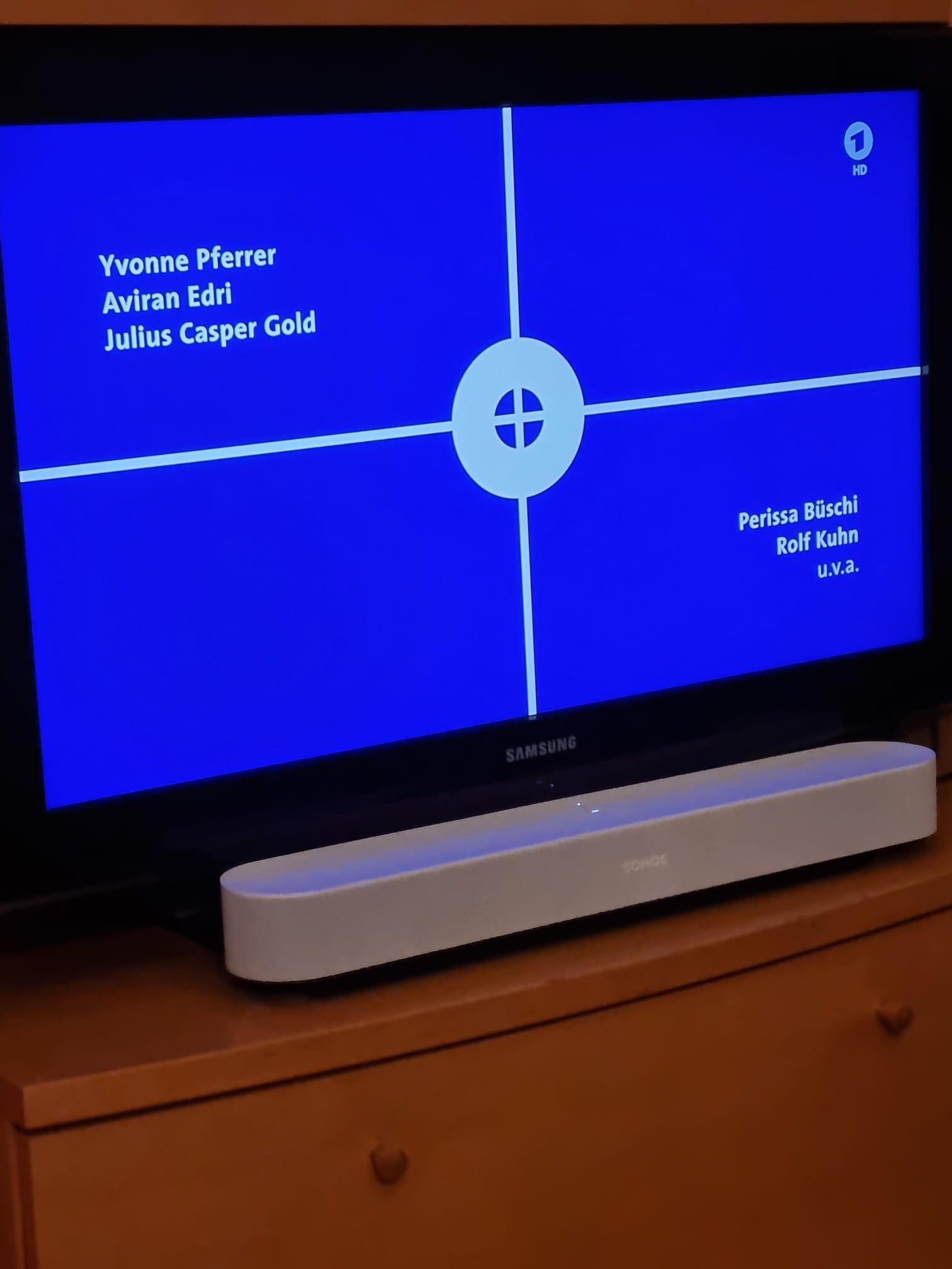 Ein Samsung-Fernseher steht auf einer Holzkommode