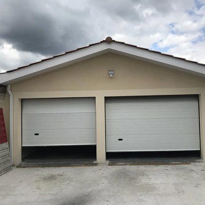 Garage avec 2 portes dont une plus ouverte que l'autre