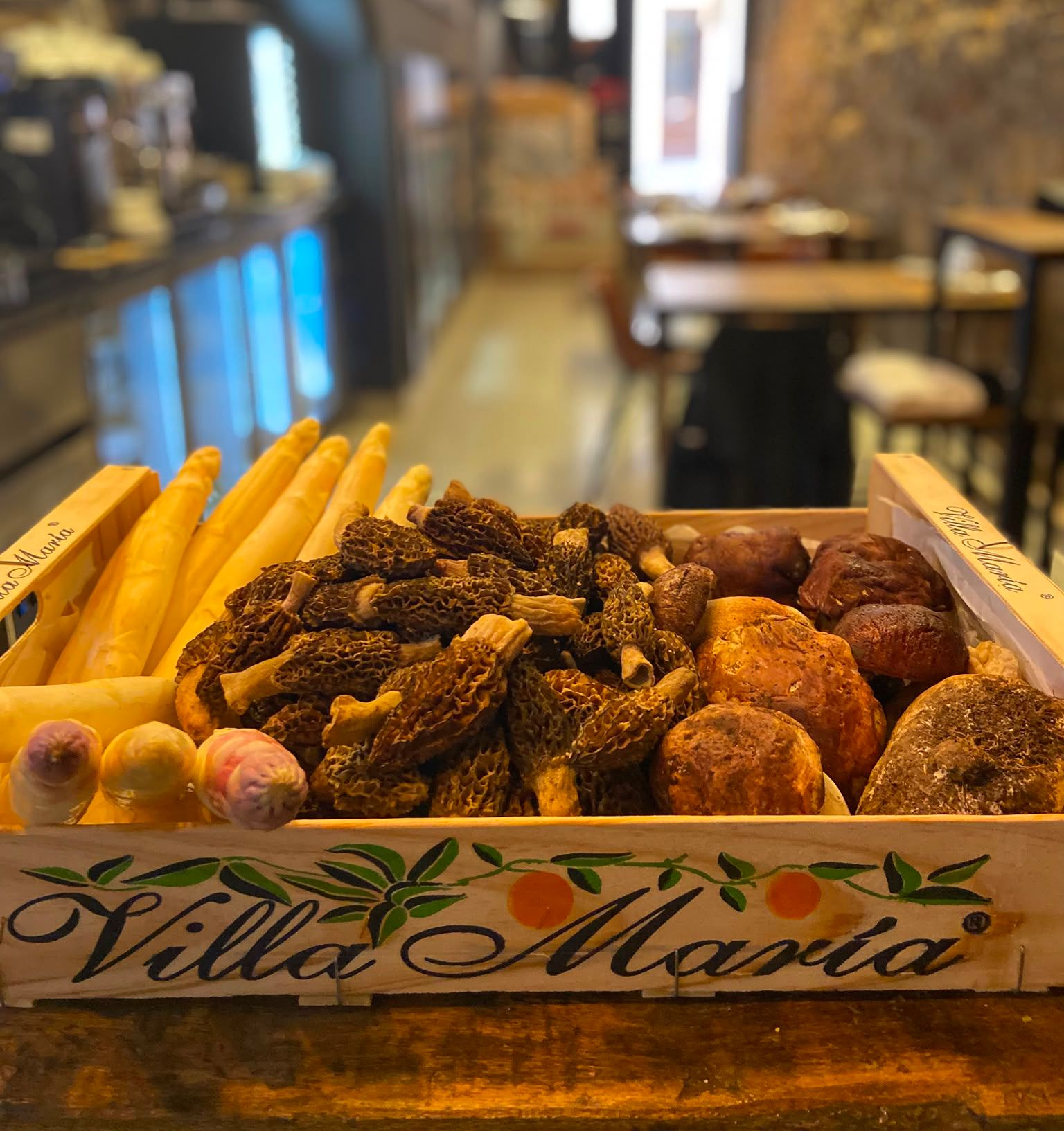Expositor de panadería con una variedad de panes y pasteles en una caja de madera en Villa Maria