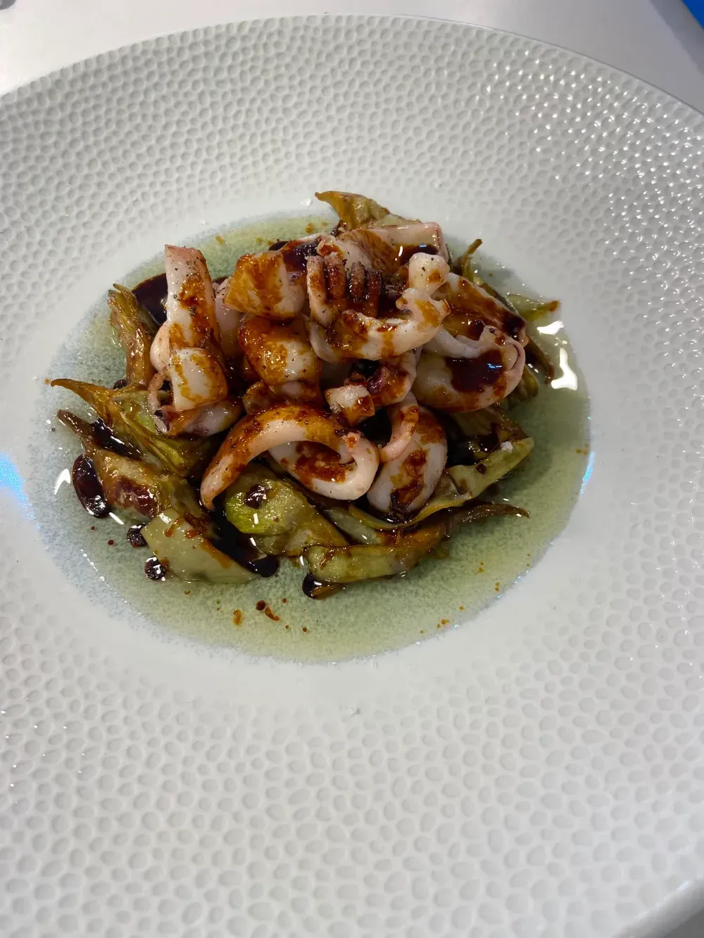 Gambas y verduras a la parrilla en un caldo ligero, servidas en un plato blanco con textura