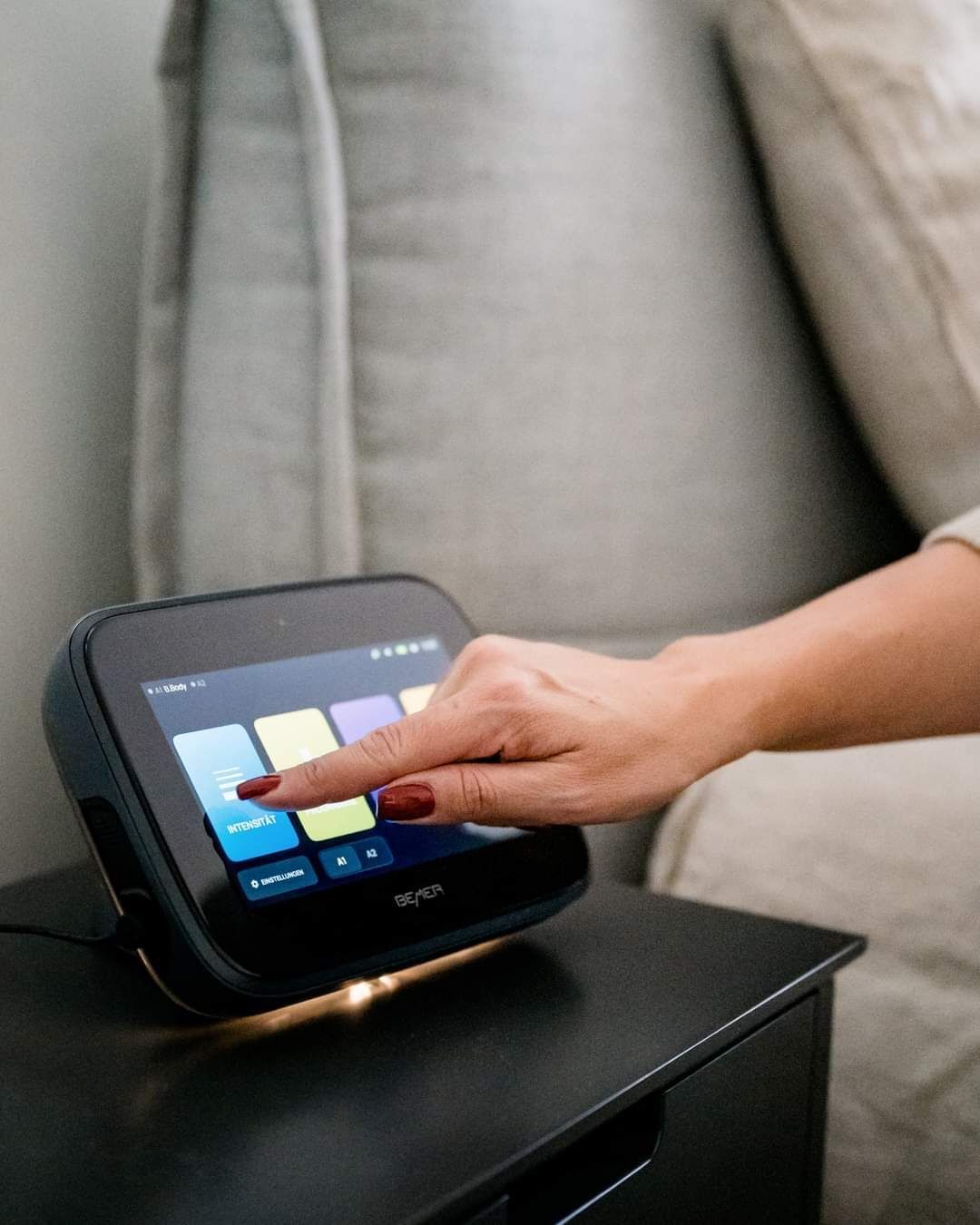 La main d'une femme appuie sur un bouton d'un appareil intelligent.