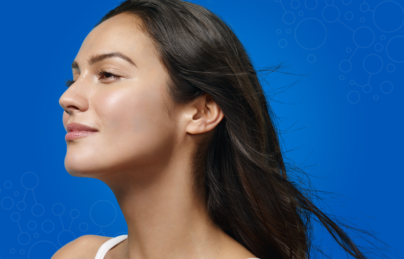 Un gros plan du visage d'une femme aux cheveux longs sur un fond bleu.