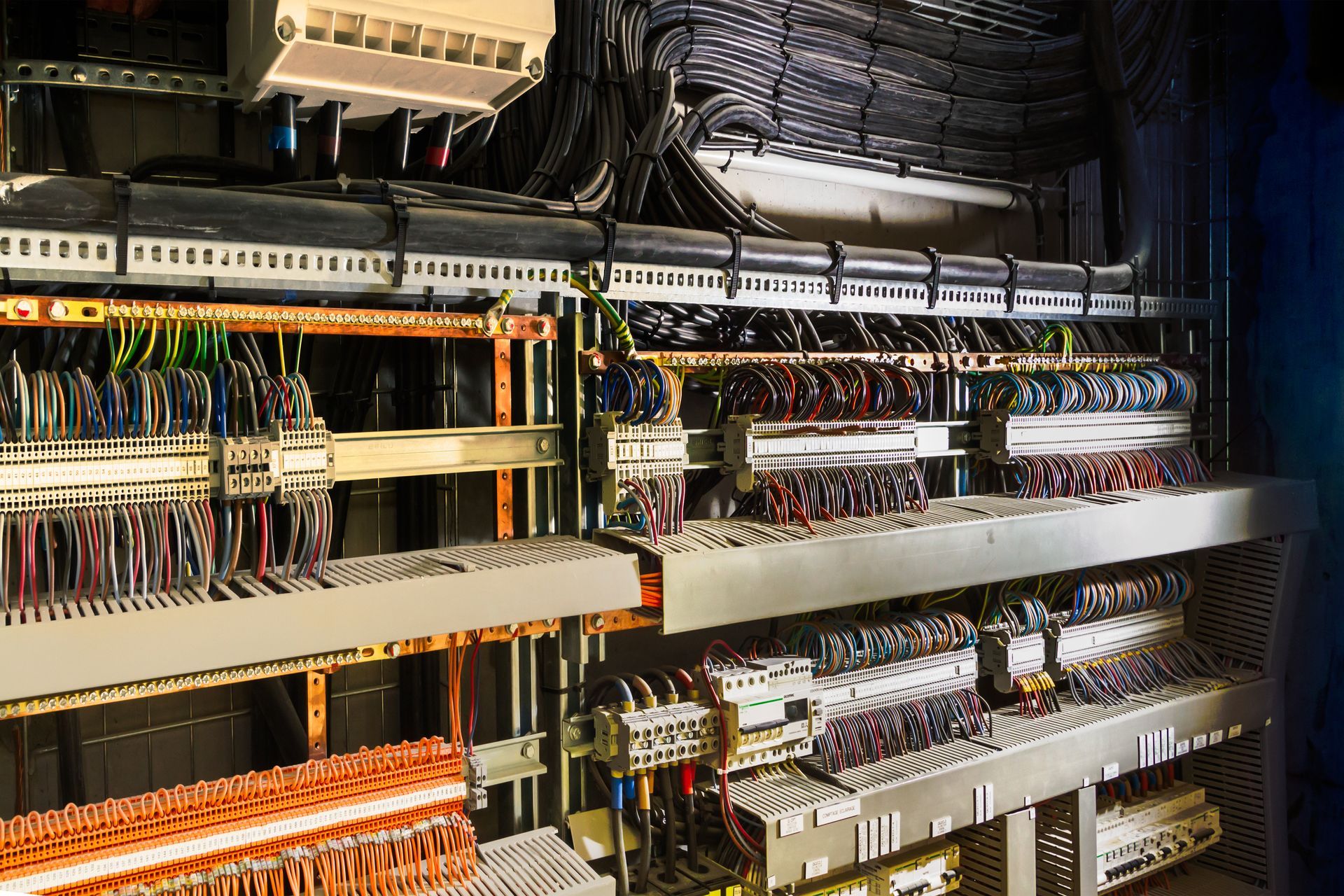 Panneau de commande électrique avec de nombreux fils et composants.