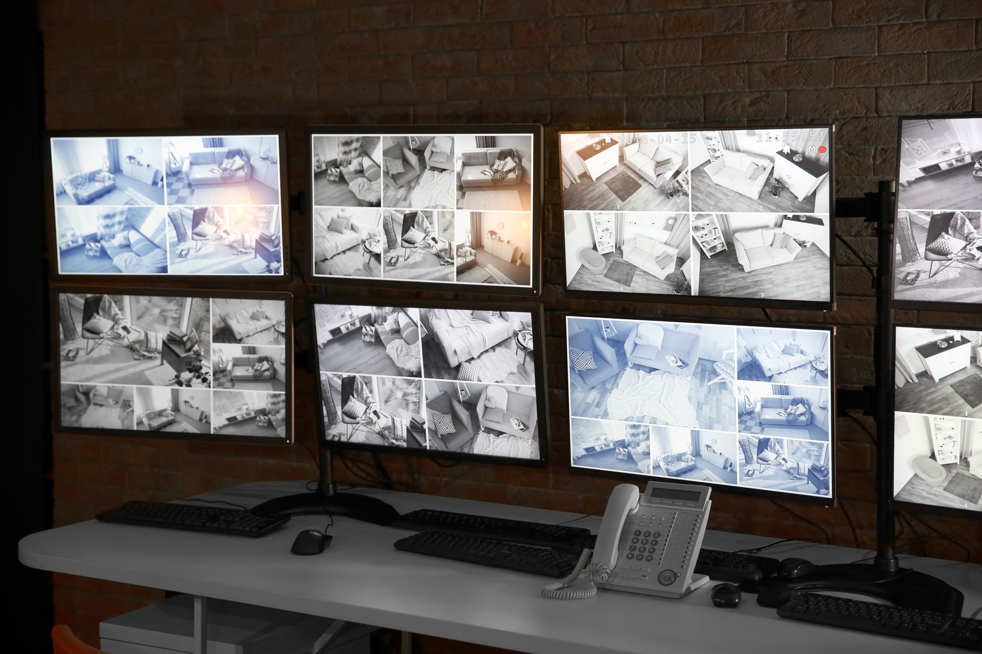 Écrans de sécurité affichant les flux de plusieurs caméras sur une table ; mur en arrière-plan.