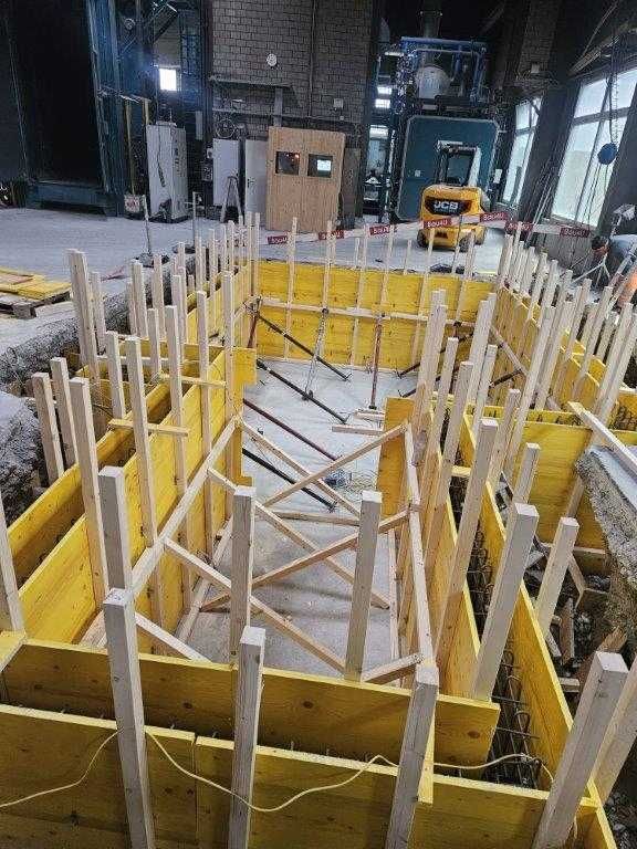 Baustelle: Gelbe Holzschalungen umgeben die Bewehrung, bereit zum Betonieren.