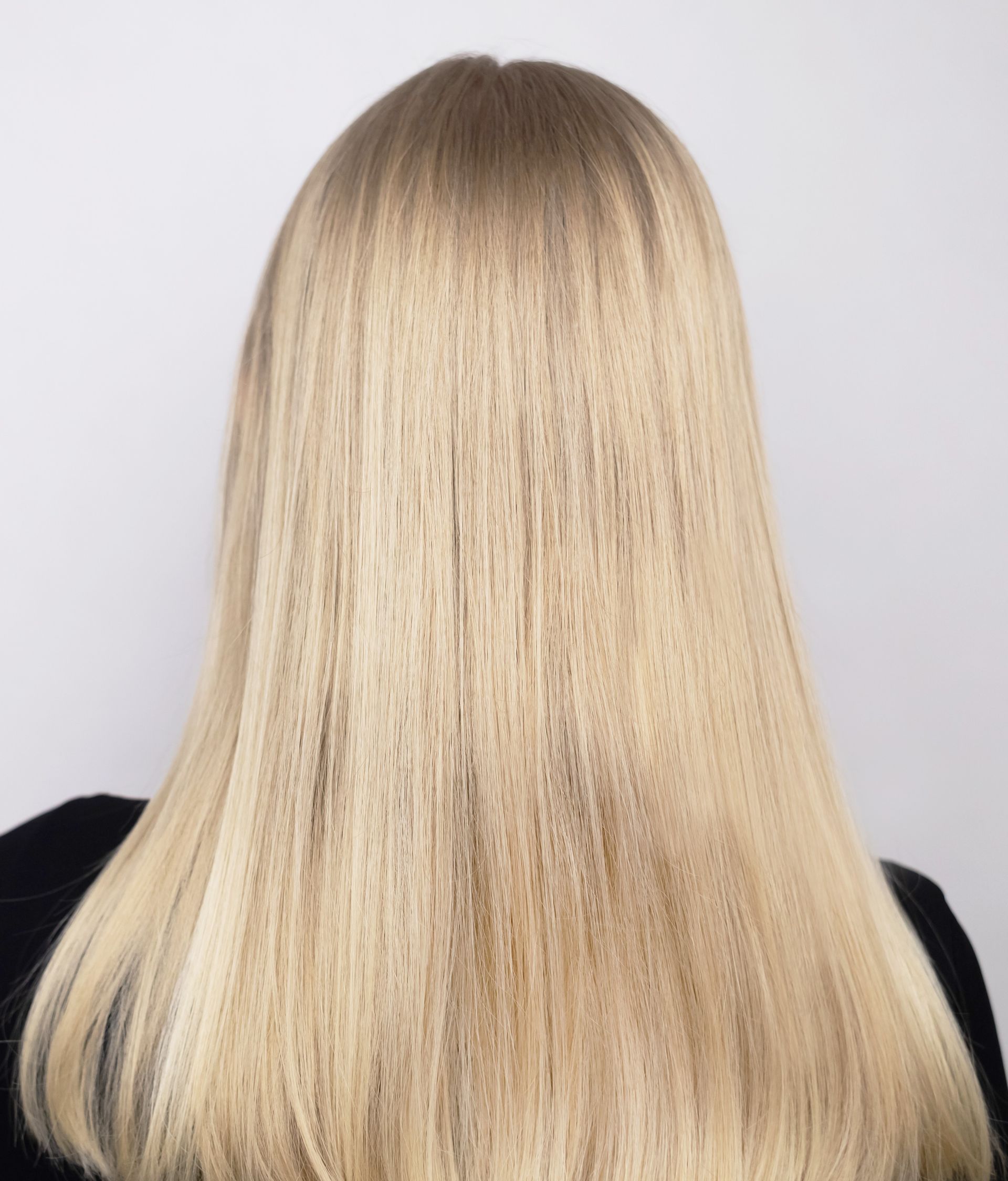 Vue de dos d'une personne aux longs cheveux blonds et lisses