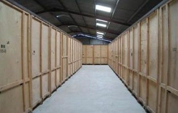 Un largo pasillo lleno de cajas de madera en un almacén.