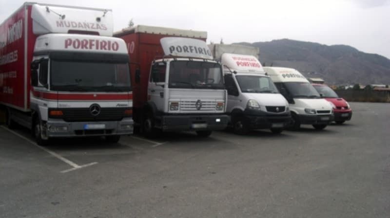 Varios camiones están estacionados en un estacionamiento uno de los cuales dice porfirio