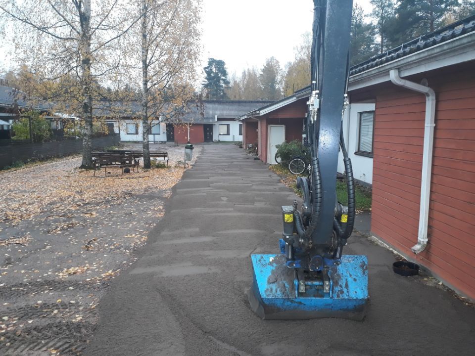 Kaivinkoneen kauha tasoittamassa