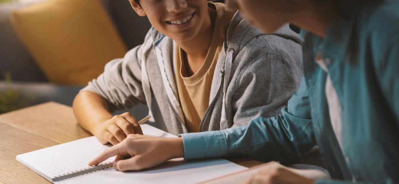 Un hombre está ayudando a un niño pequeño con su tarea.