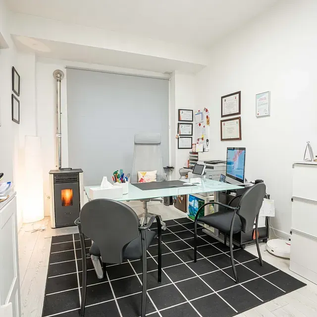 Una habitación con un escritorio y sillas.