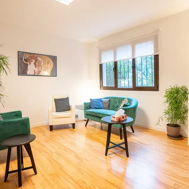 Una sala de estar con un sofá, sillas y una mesa.