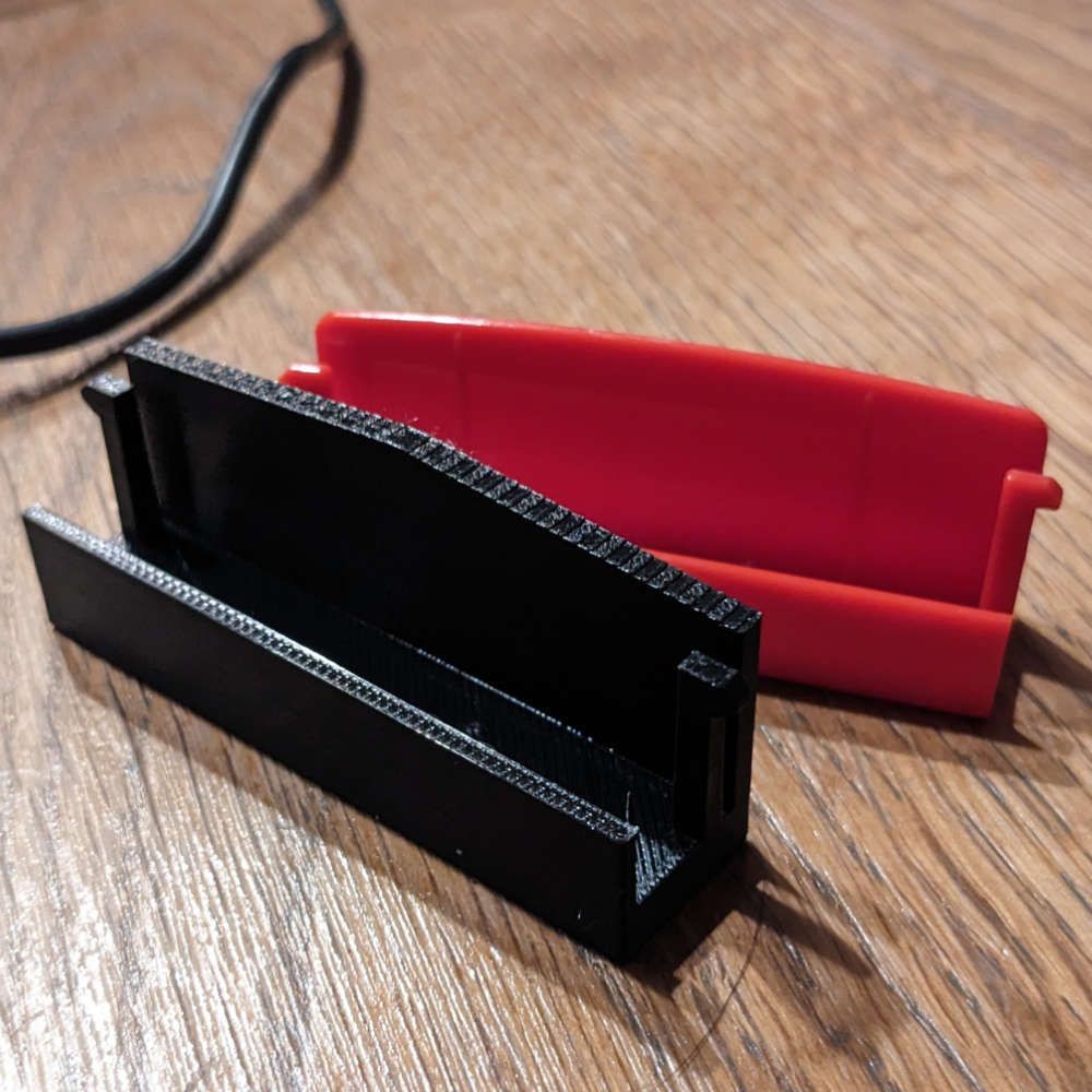 Schwarze und rote, Kuchenplattenhalter auf einer Holzoberfläche.