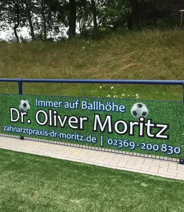 Werbung von Dr. Oliver Moritz als Banner an einem Fußballzaun