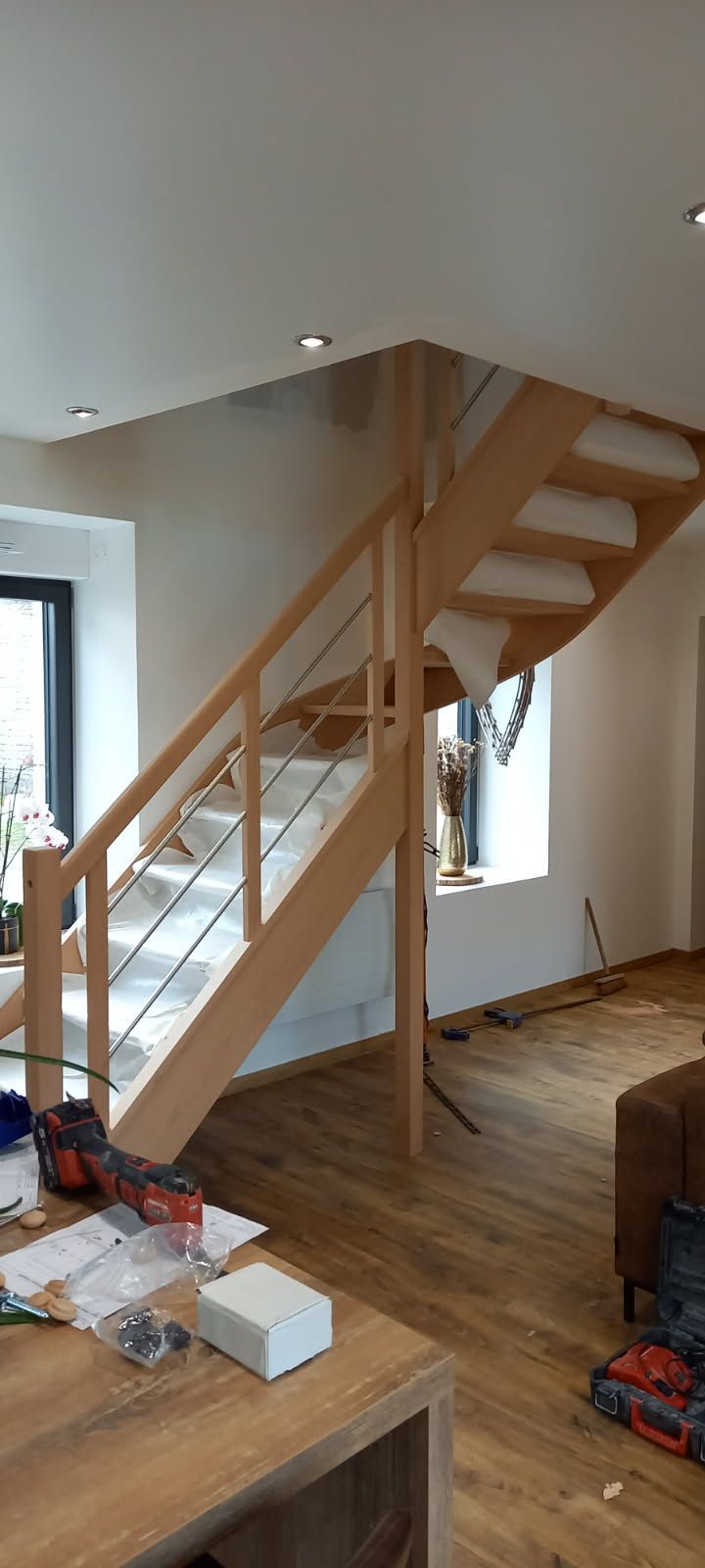 Escalier en bois avec garde-corps en métal dans un intérieur moderne.