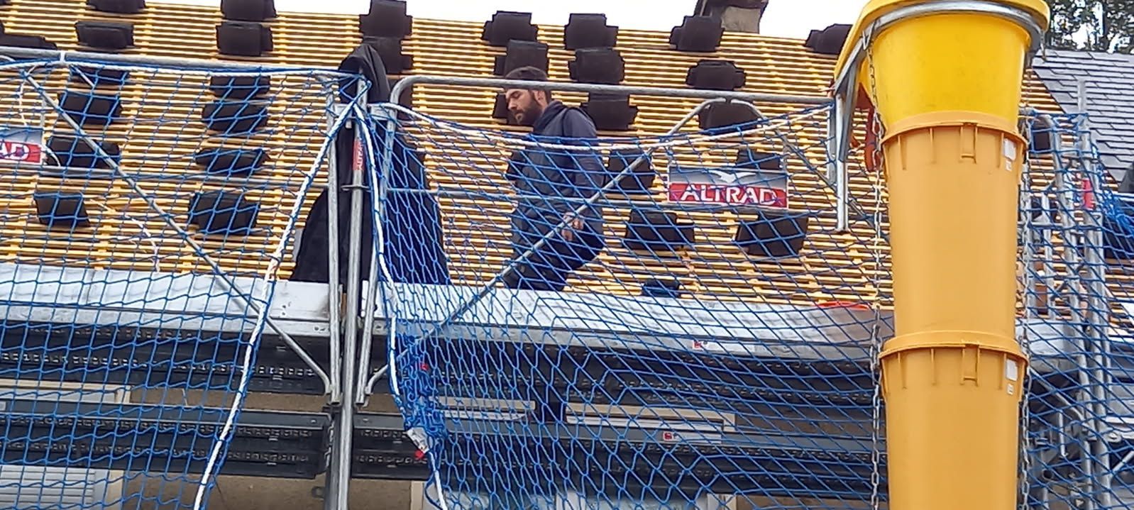 Chantier de construction avec coffrage pour un bâtiment, et un tas de poutres en bois.