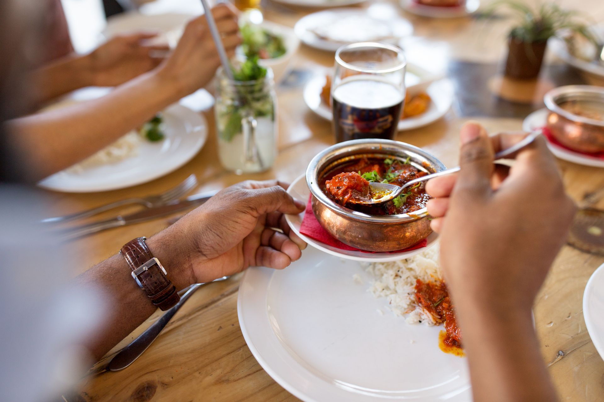 Personne qui se sert dans un plat indien