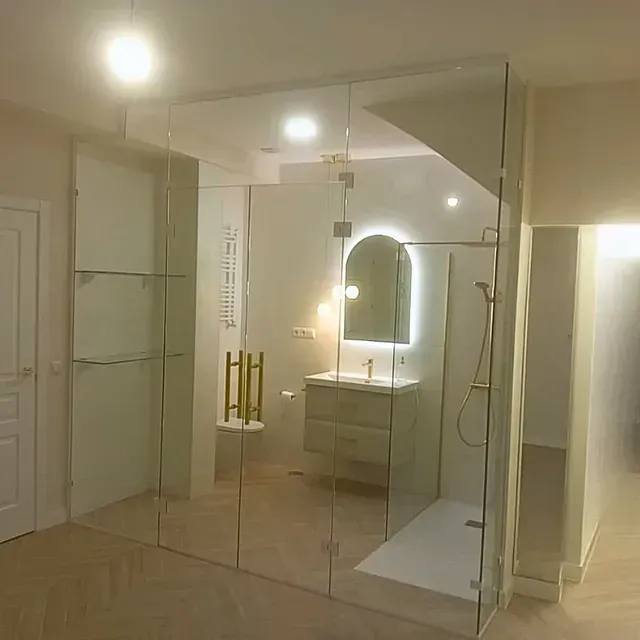 Un baño con lavabo, espejo y cabina de ducha.