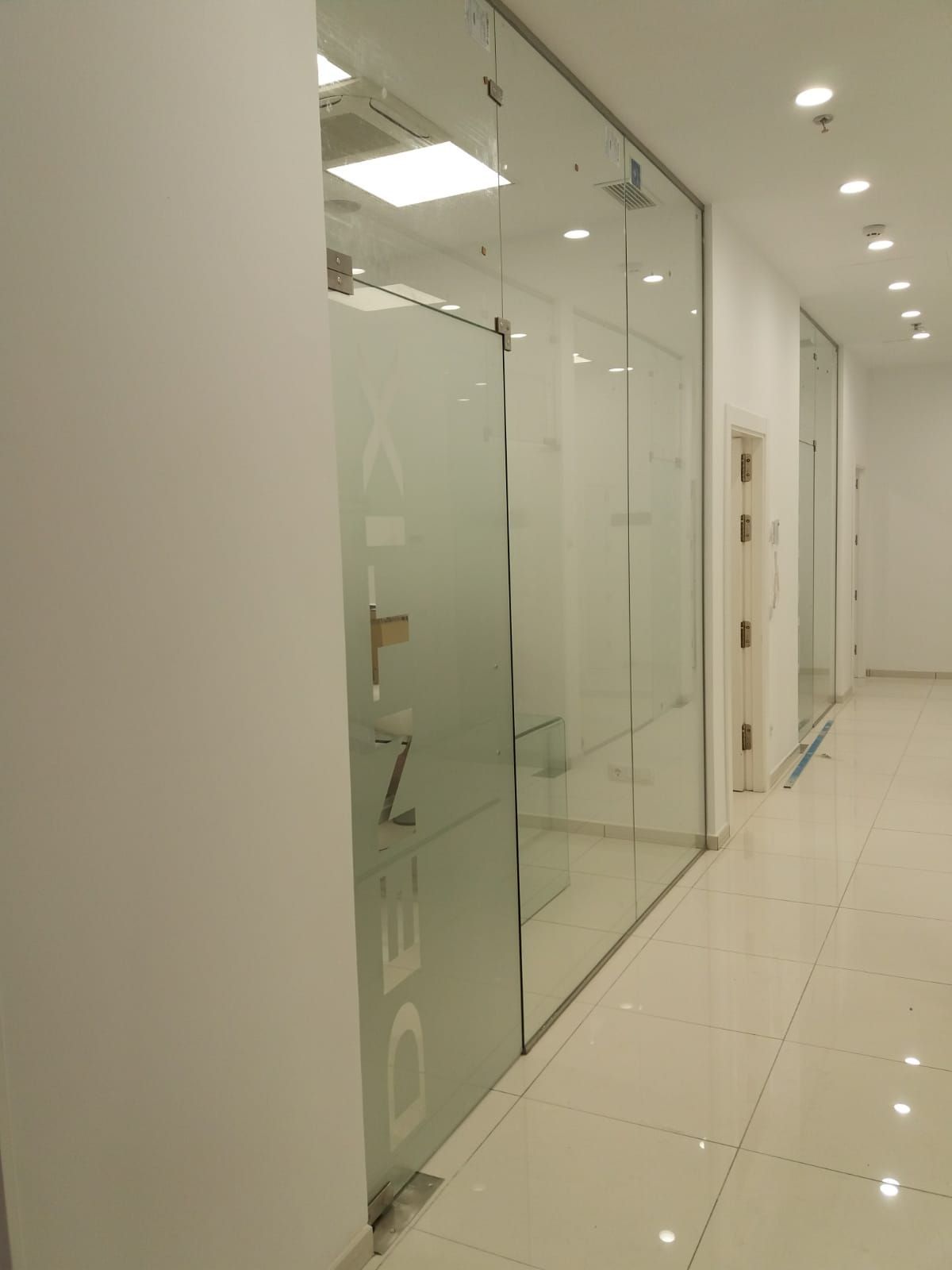 Un pasillo con una pared de vidrio que dice