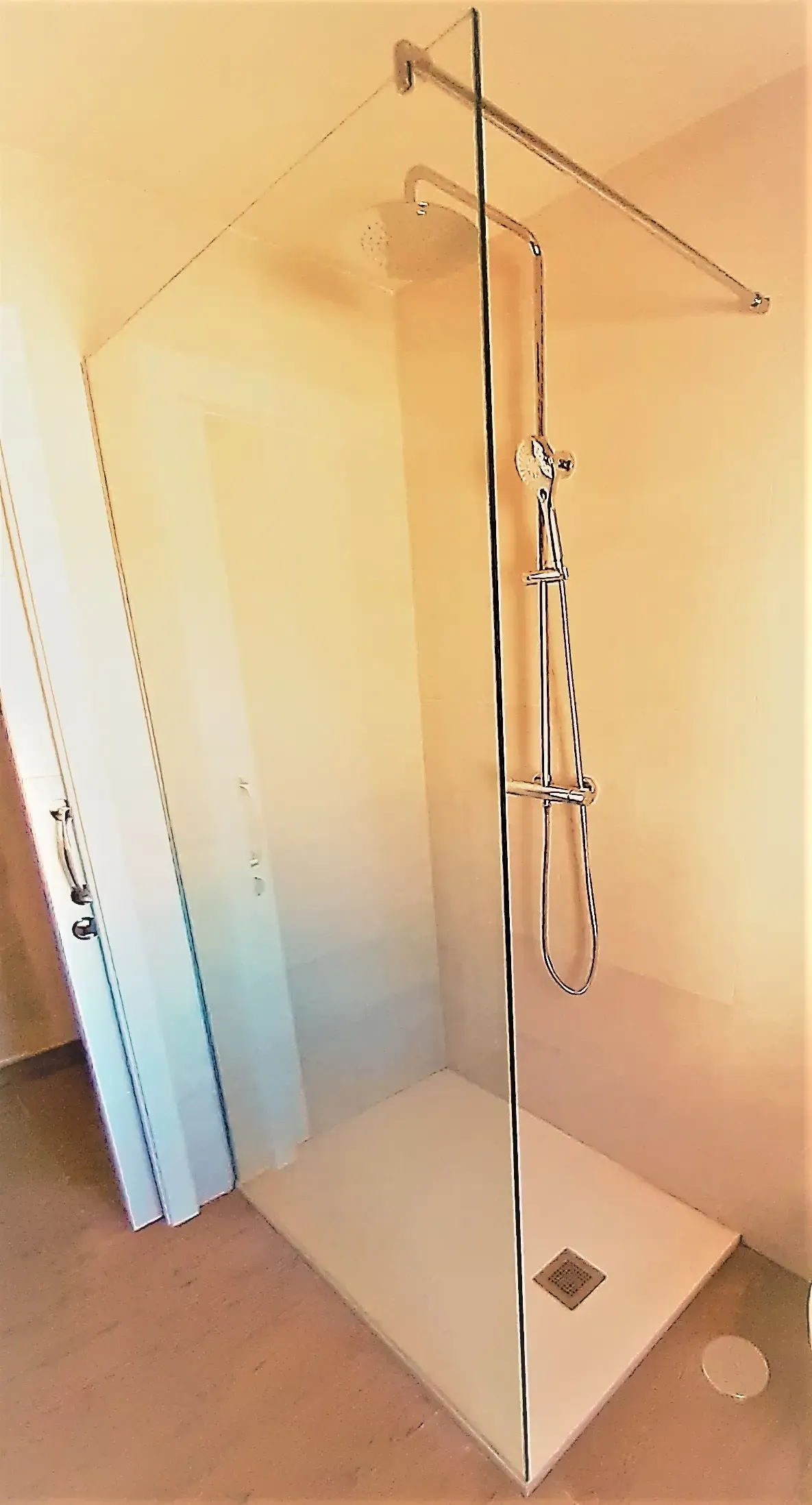 Un baño con ducha a ras de suelo y cabezal de ducha.