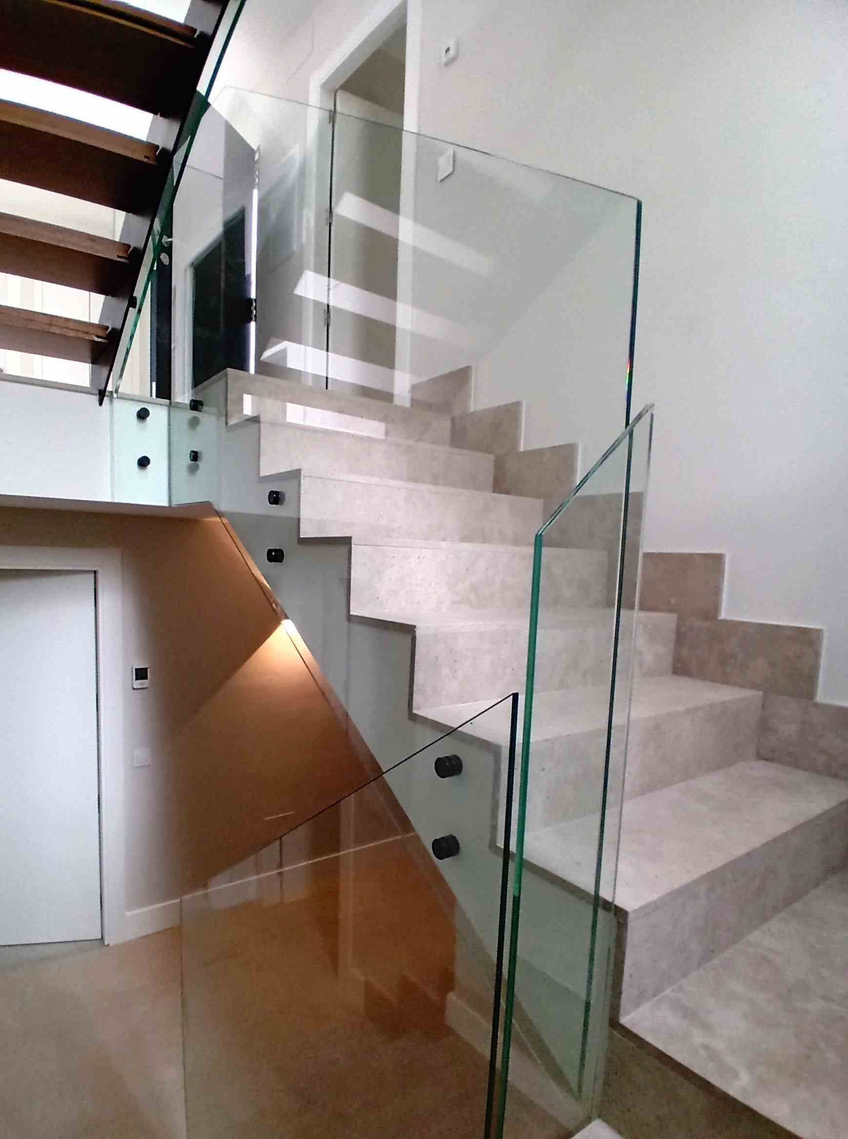 Una escalera con barandilla de cristal en una casa