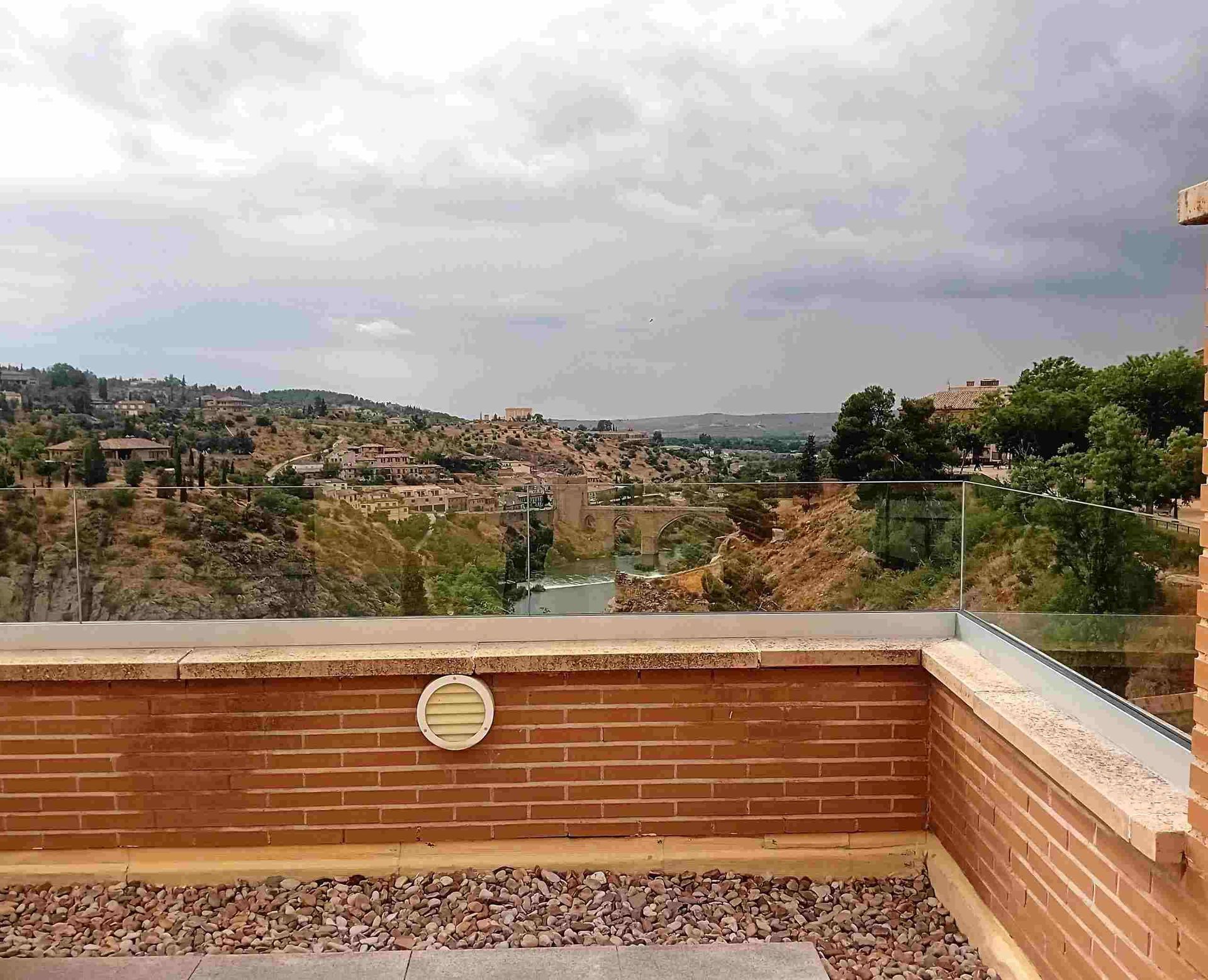 Un balcón con vista a la ciudad y las montañas.