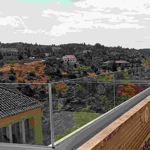 Una vista de una ciudad desde un balcón con barandilla de cristal.
