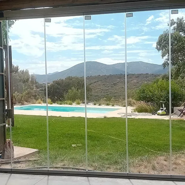 Una vista de una piscina a través de una puerta corrediza de vidrio.