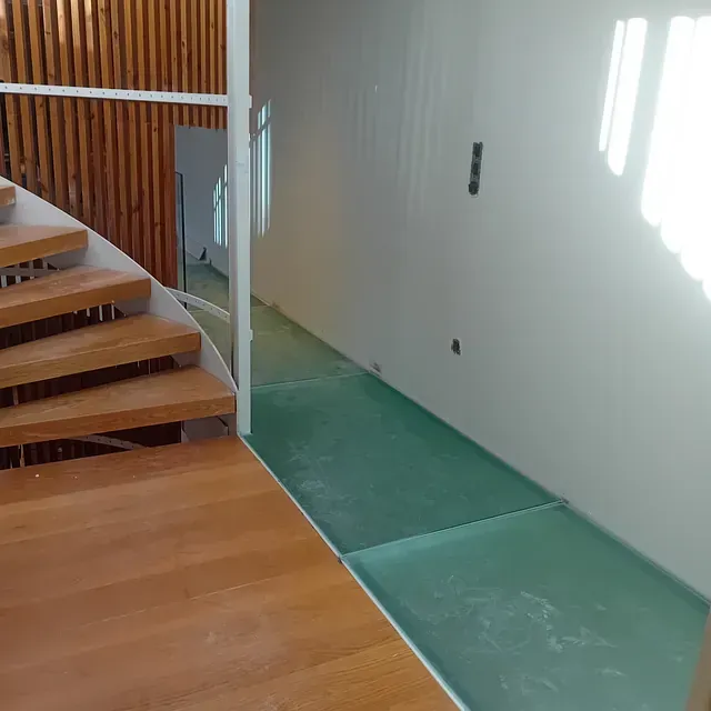 Una escalera con escalones de madera y suelo verde.