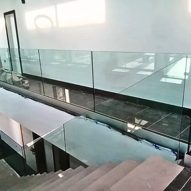 Una escalera con barandilla de cristal y escalones de madera.