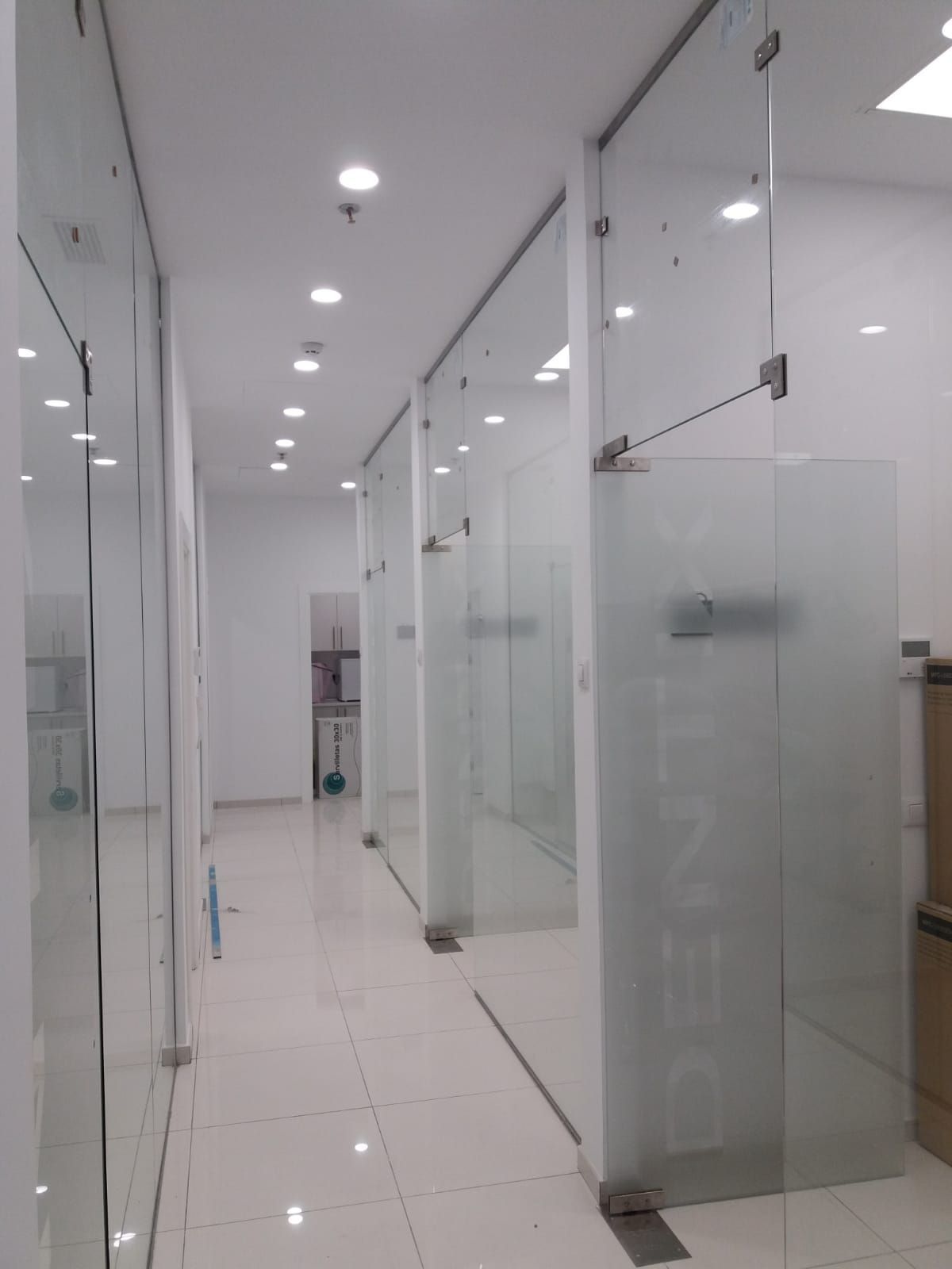 Un largo pasillo con muchas paredes de vidrio.