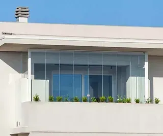 Un balcón con muchas ventanas y plantas.