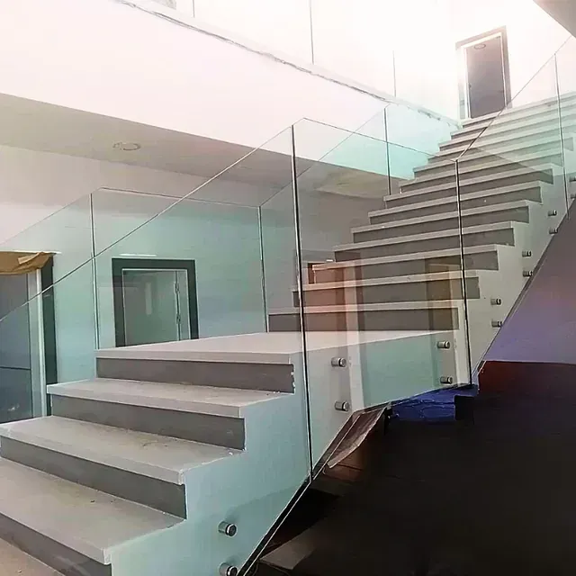Una escalera con barandilla de cristal en una casa.