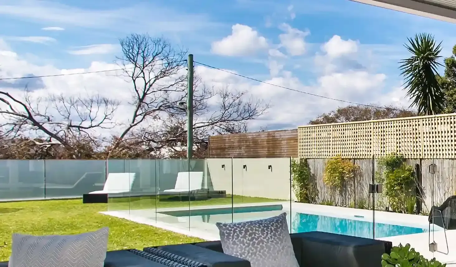 Hay una piscina en el patio trasero con una valla alrededor.