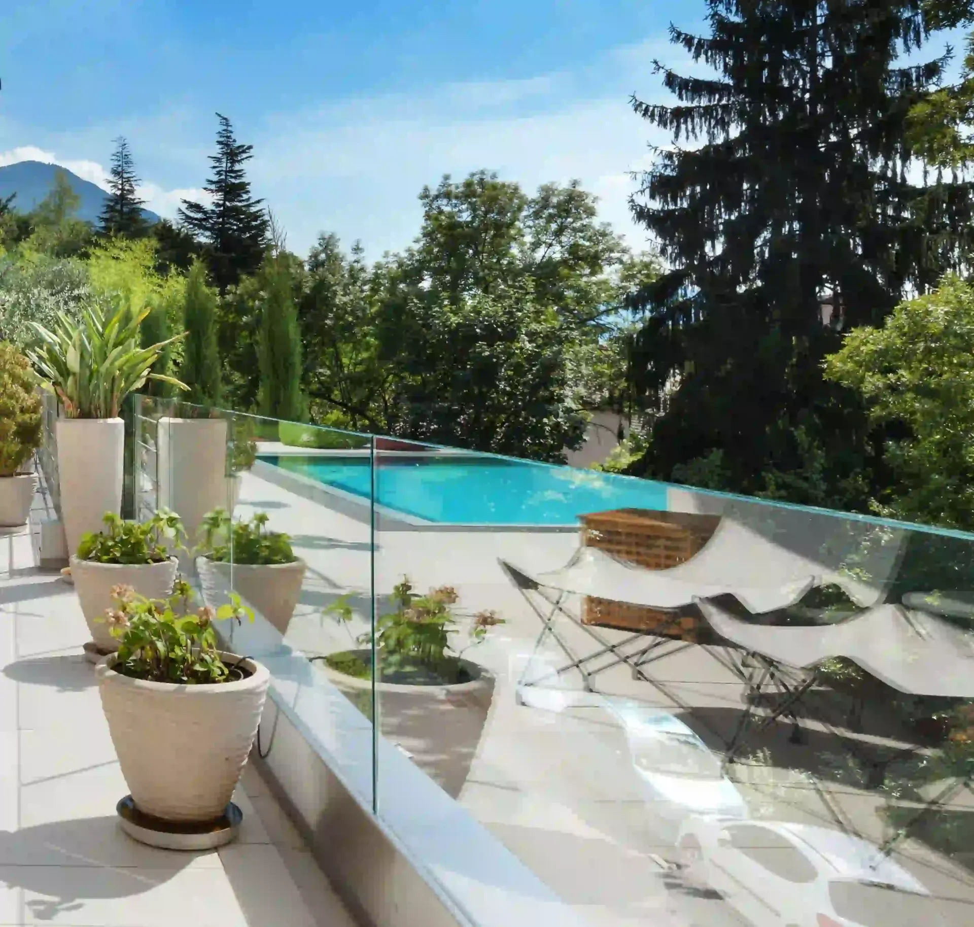 Un balcón con plantas en macetas y una piscina.