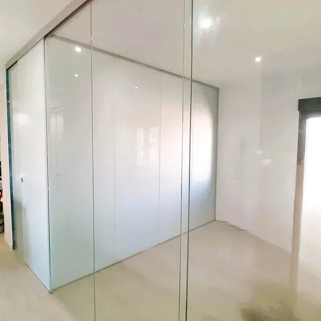 Una habitación con paredes blancas y puertas corredizas de vidrio.