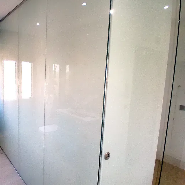 Una pared blanca con una puerta corrediza de vidrio en una habitación.