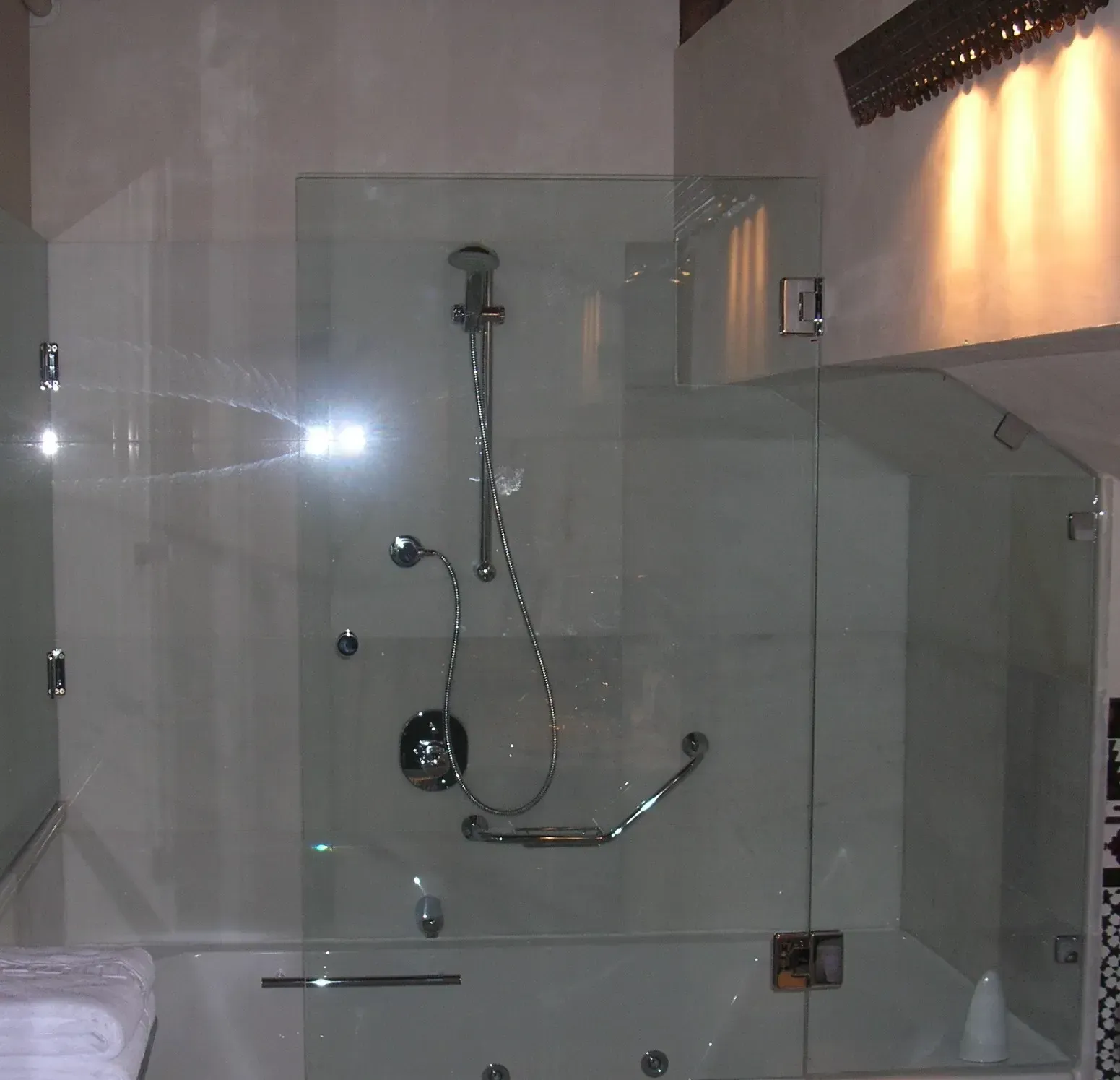 Un baño con puerta de ducha de cristal y bañera.