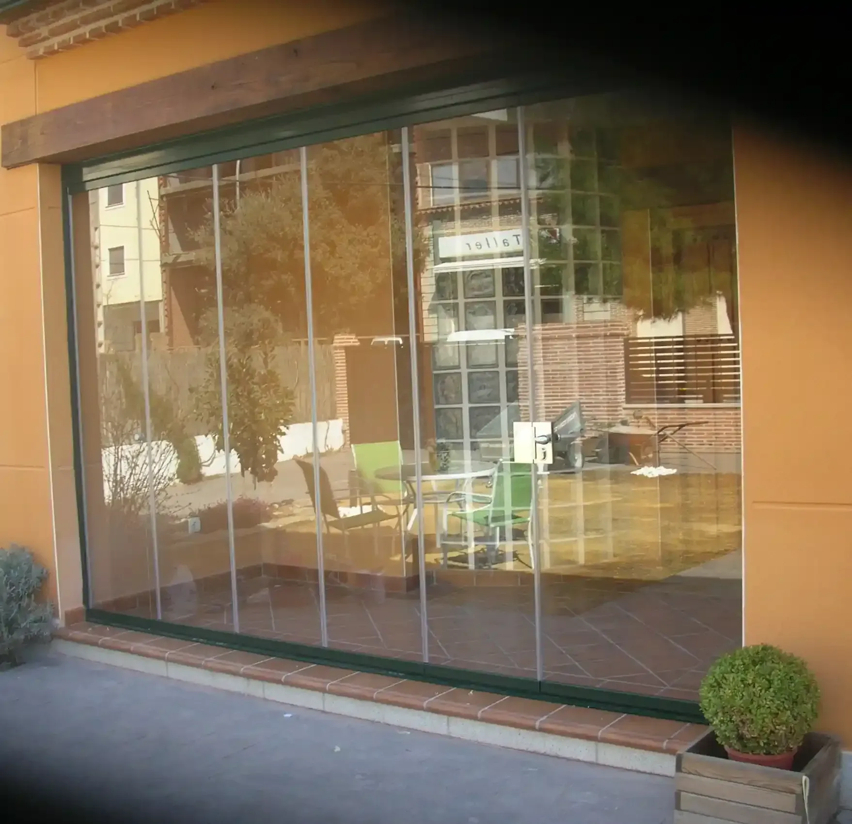 Una gran ventana con el reflejo de un edificio con la letra h en él.