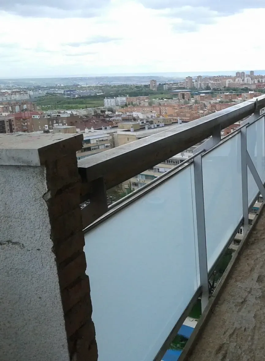 Un balcón con vista a una ciudad y al océano.