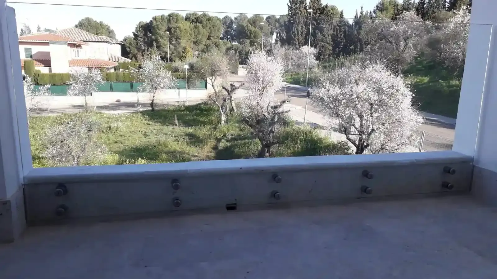 Un balcón con vista a un parque y árboles.