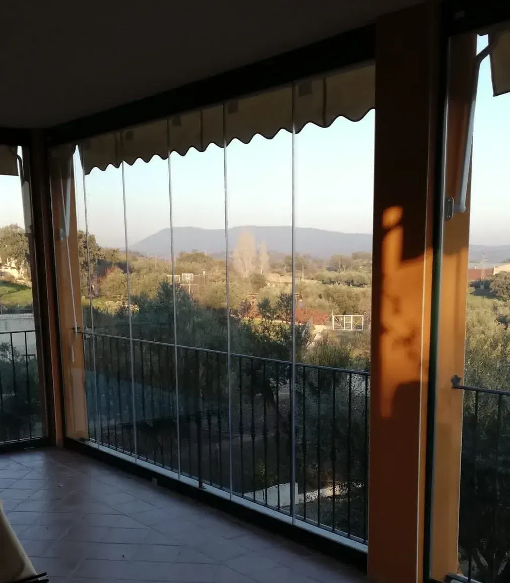 Un balcón con vista a las montañas y los árboles.