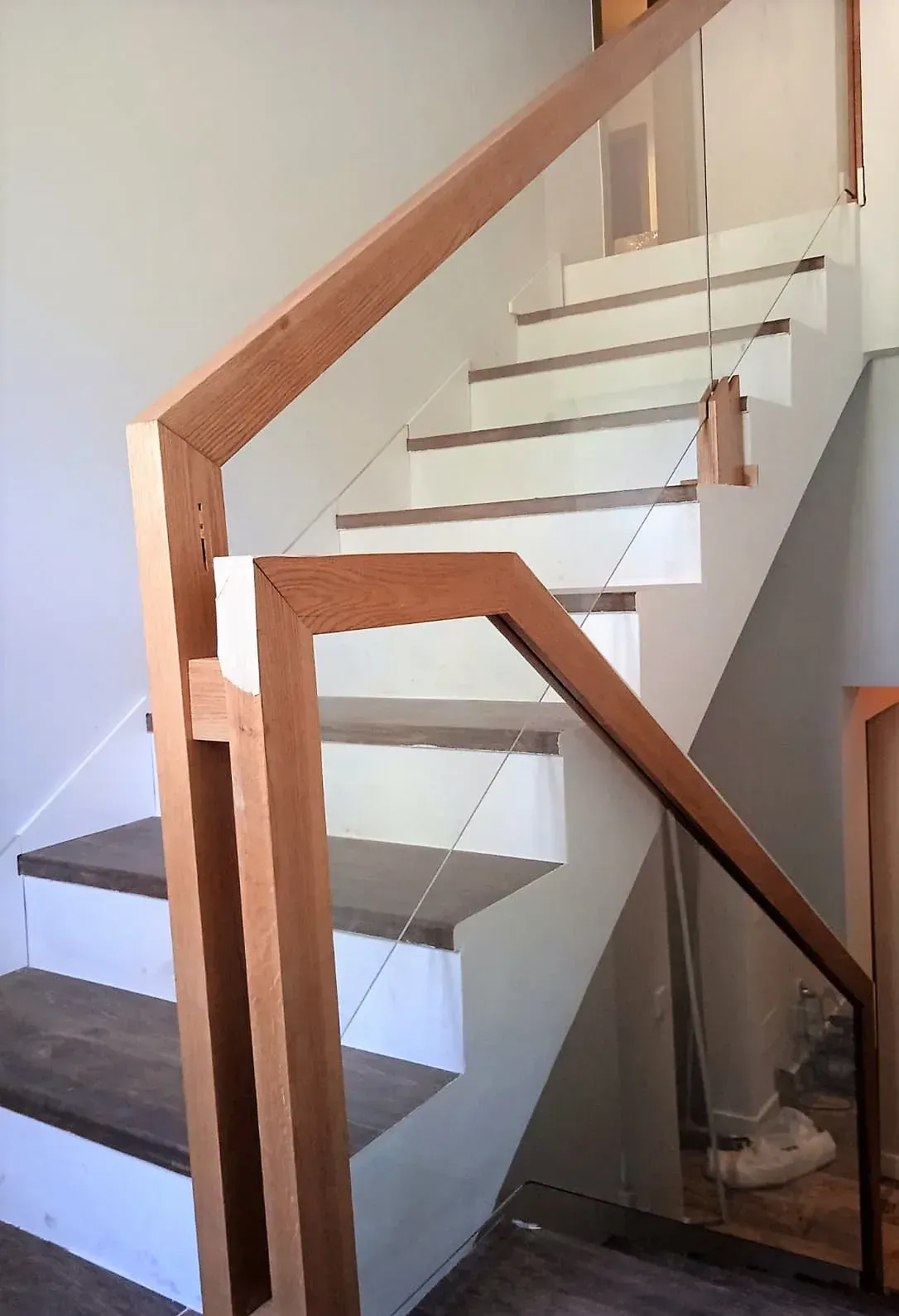 Una escalera con barandilla de madera y barandilla de cristal