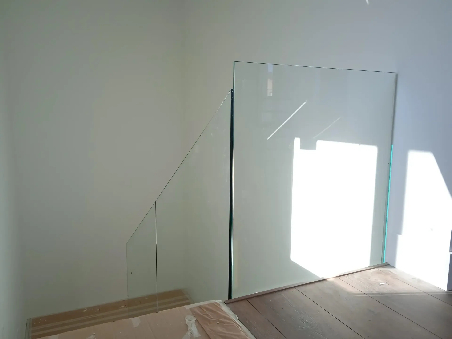 Una habitación con escalera y barandilla de cristal